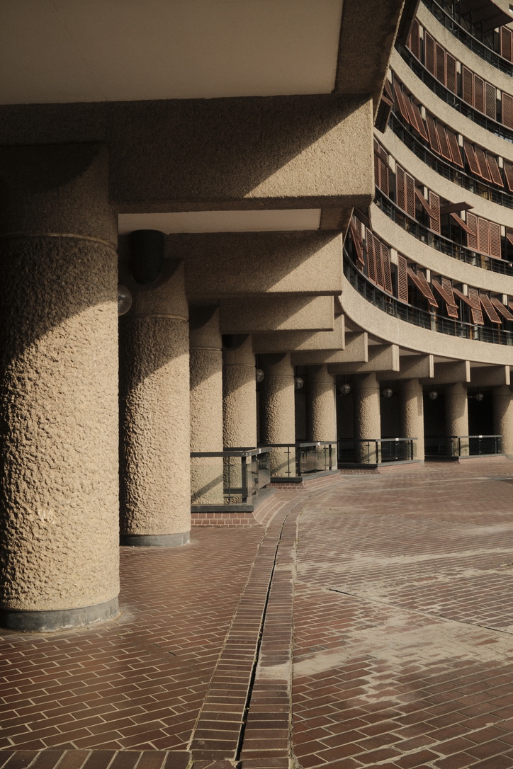 A rhythmic line of concrete columns curving beneath a city building