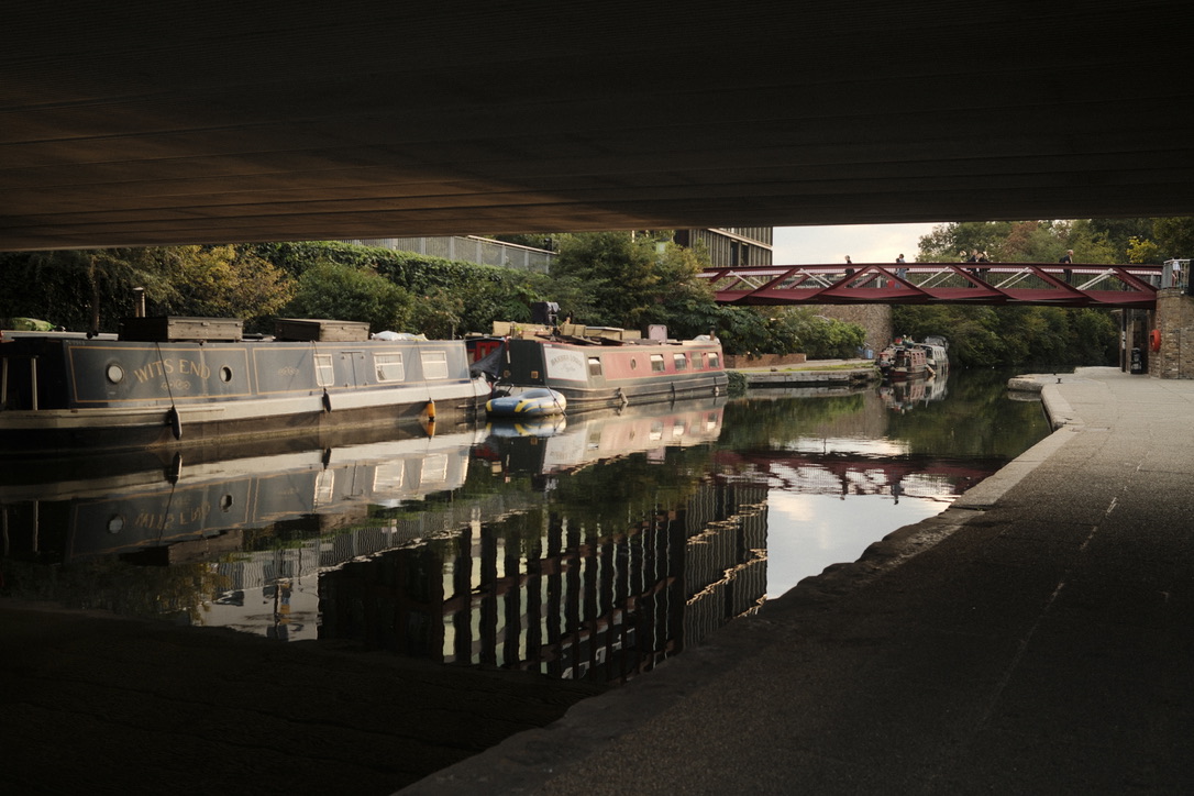 A canal and bridge seen from beneath a dark structure
