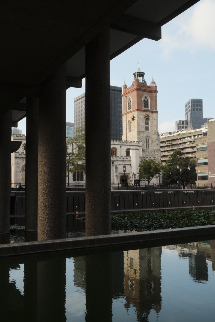 Concrete columns frame a tower and its reflection