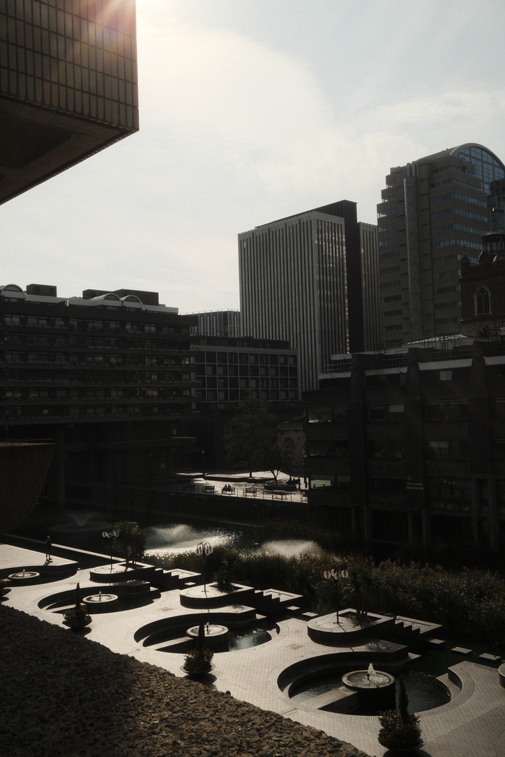 Sunlight and shadows fall across a courtyard enclosed by concrete buildings