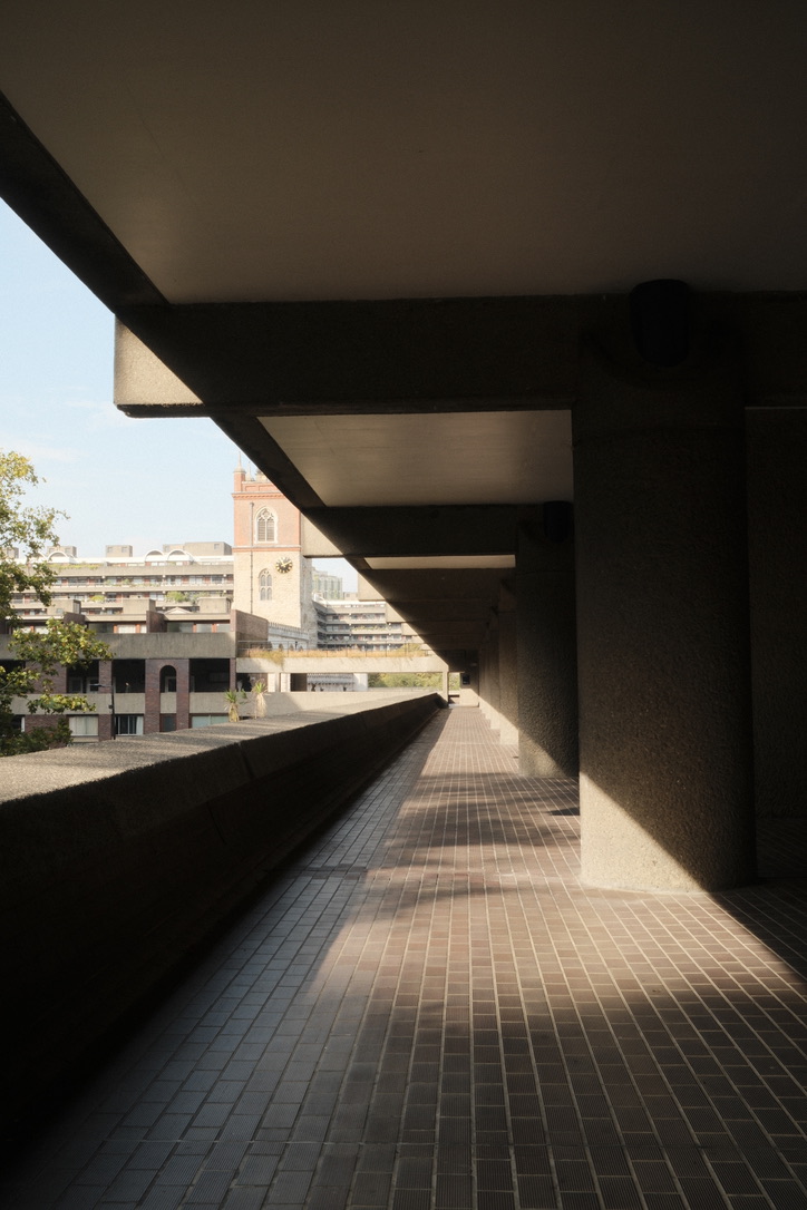 Sunlight repeats between the deep shadows of a concrete walkway